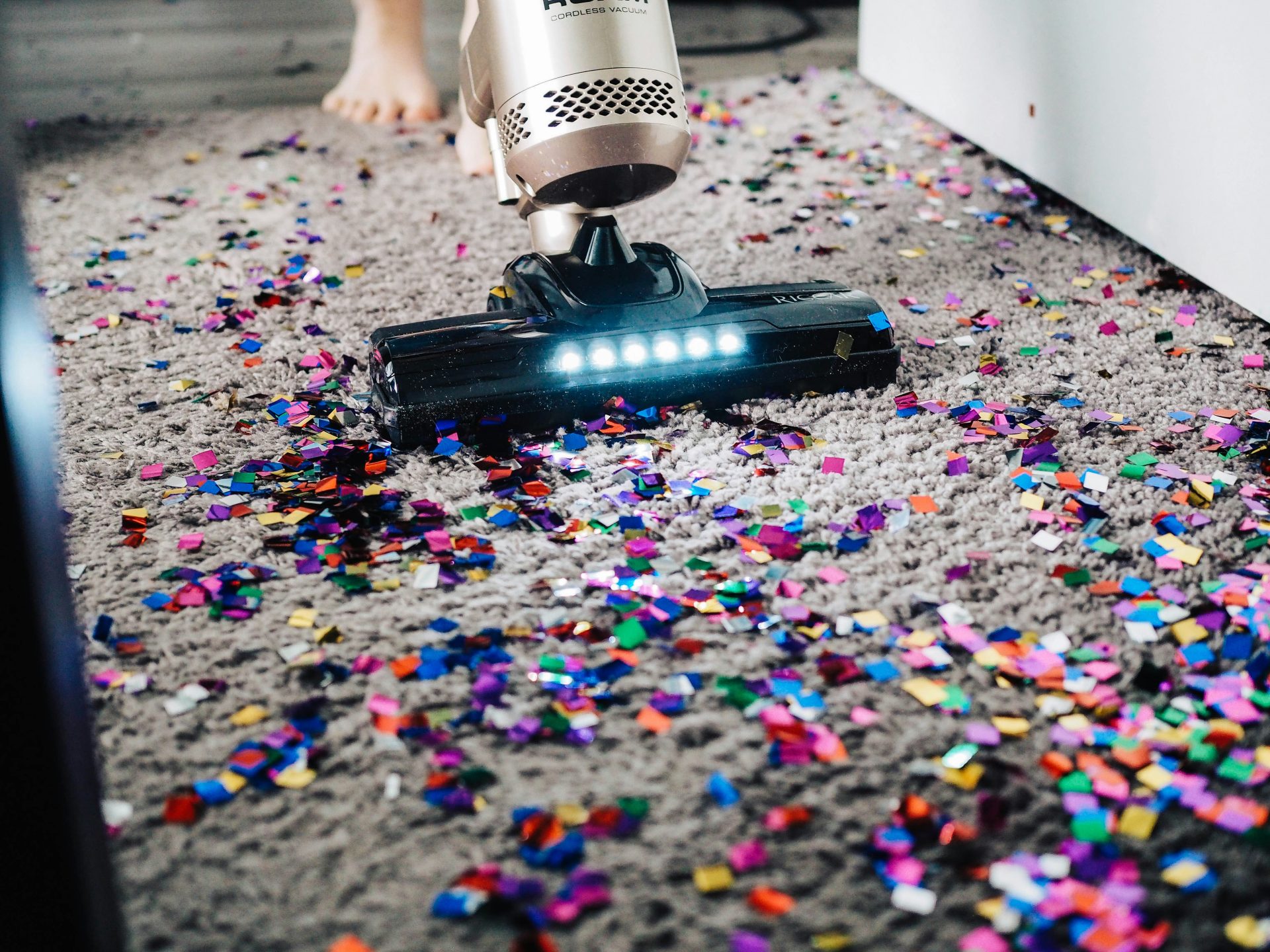 une personne utilisant un aspirateur pour nettoyer un tapis